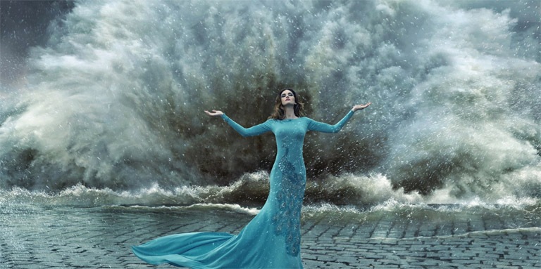 девушка в голубом платье и шторм позади нее